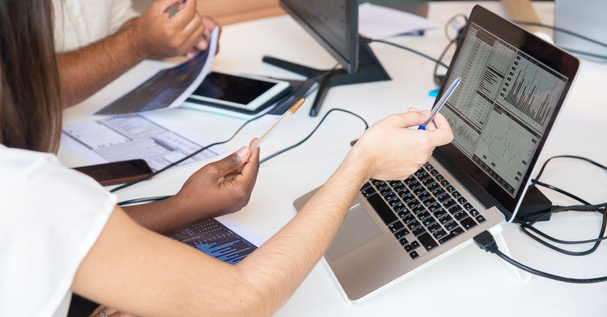 Two marketing professionals reviewing analytics dashboards and performance reports in a meeting