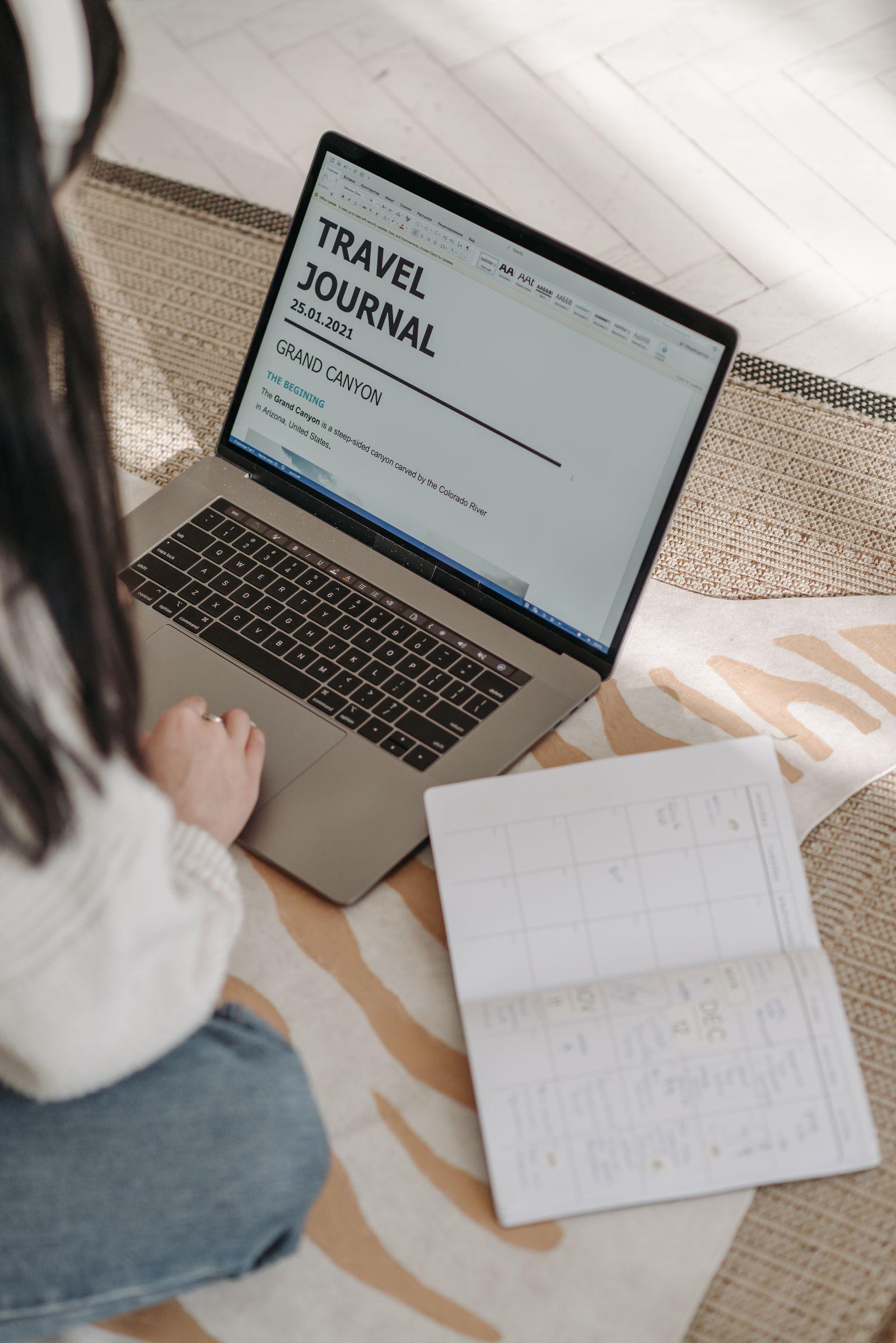 Woman planning travel with a laptop and notebook